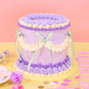 Vintage Cake - Tonal Colour by Crumbs & Doilies, tall 6-layer cake with purple and cream Swiss Meringue icing and ribbon decoration.